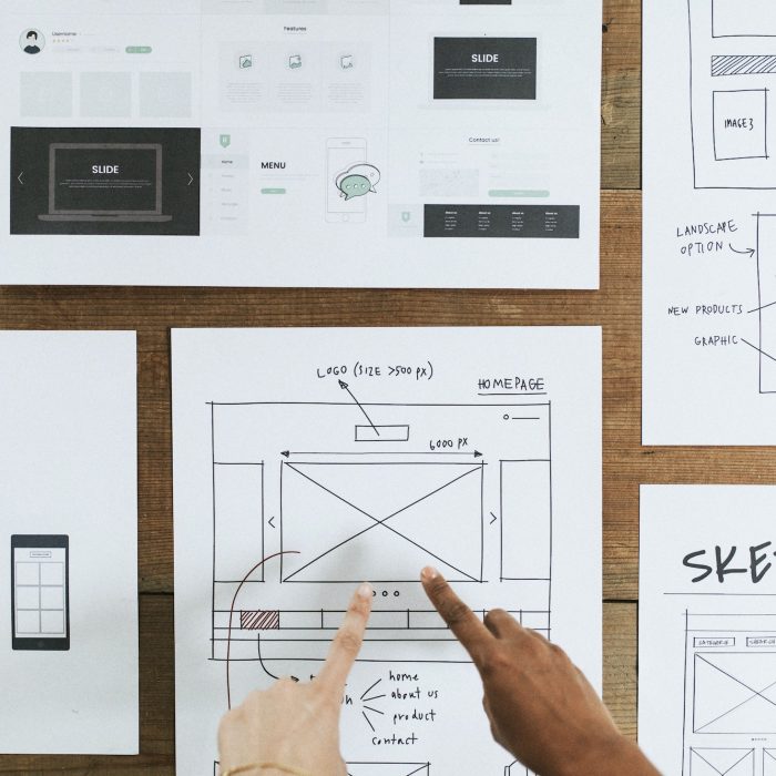 Hands point to web design document Hands point to web design document